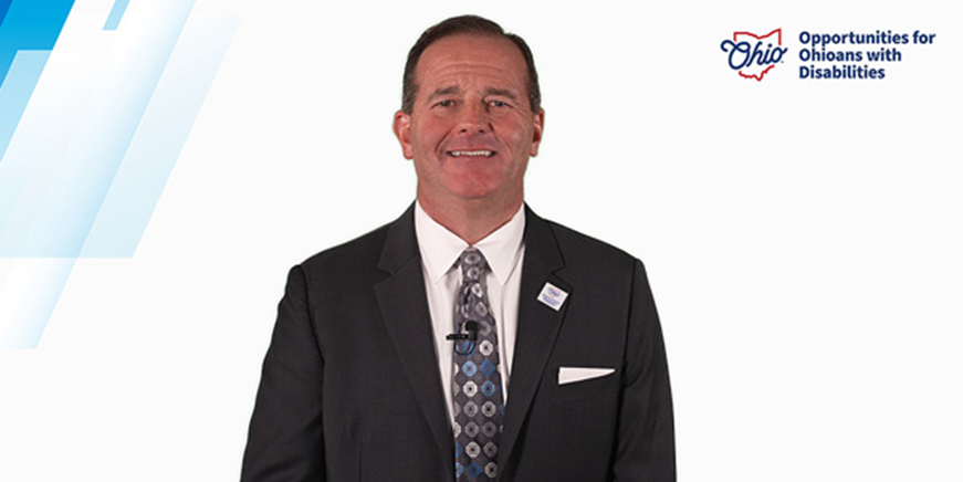 Director Kevin Miller in a suit, smiling.