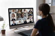 Woman in front of computer screen engaged in virtual meeting