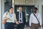 Three professionals walking while having discussion