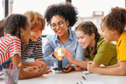 Teacher showing students how electricity works to light a bulb