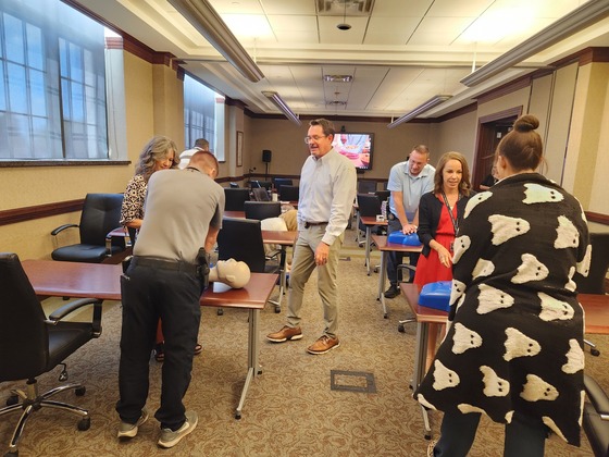 OAG employees practicing CPR at a Narcan/CPR training for Overdose Awareness Day