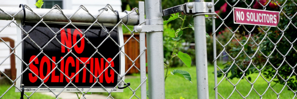 No Soliciting signs hanging on a fence