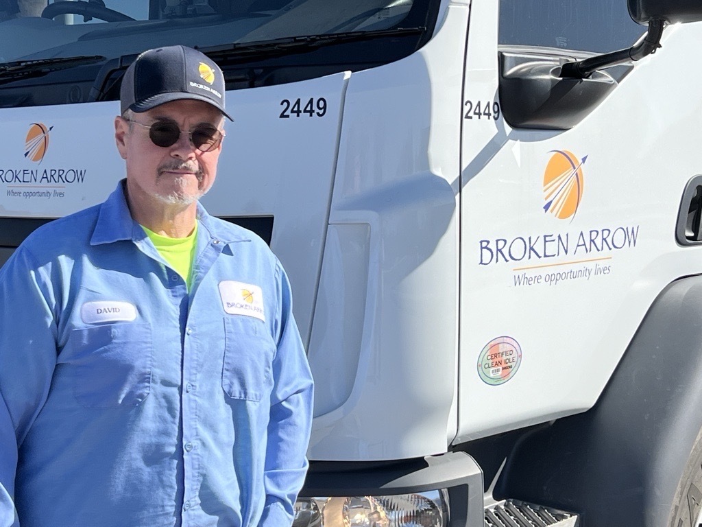 David Heard standing by the street sweeper truck. 