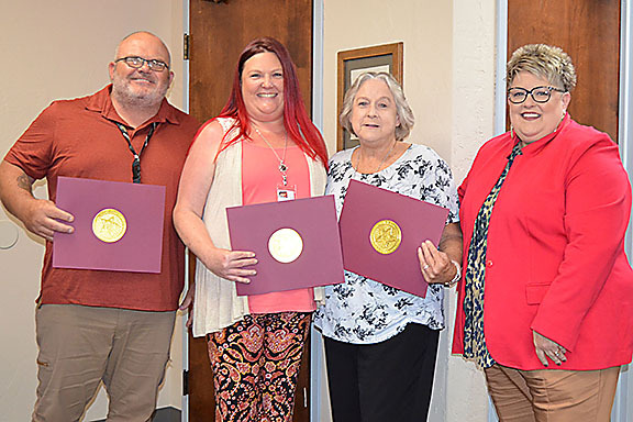 Four people smiling.