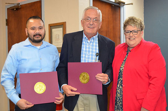 Three people smiling.