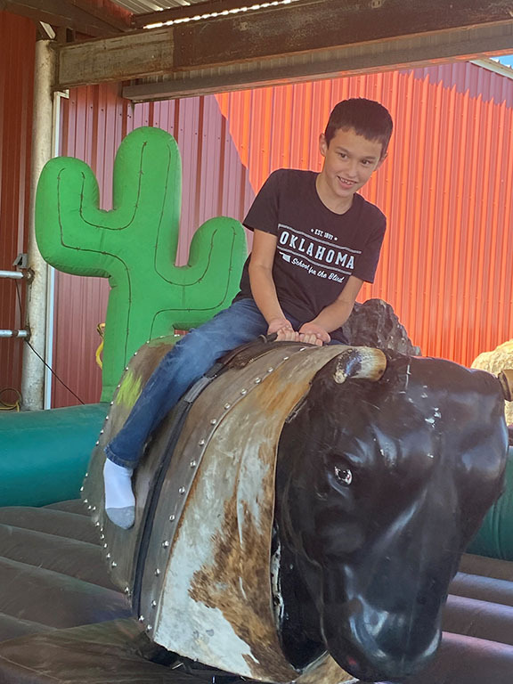 Boy riding mechanical bull.