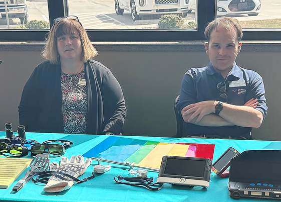Two people sitting behind table.