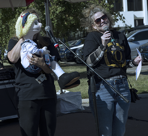 Two women with one holding a puppet.