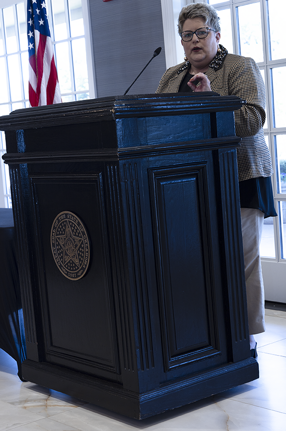 Woman speaking at lectern.