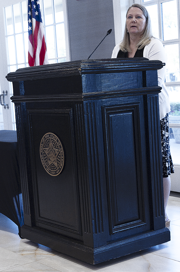 Woman speaking to room.
