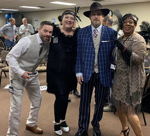 Four people dressed in 1920 era clothing.