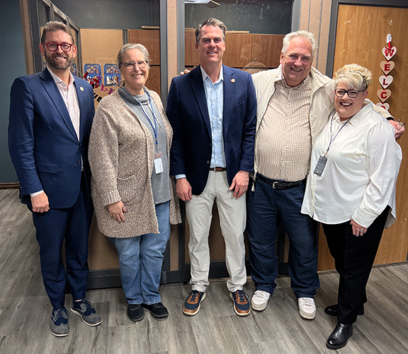 Five people in picture with Oklahoma Gov. Kevin Stitt in center.