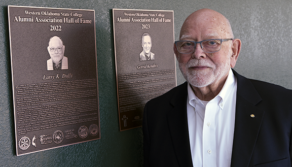 Man standing next to plaque.