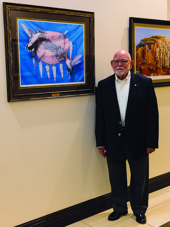 Man standing next to painting.
