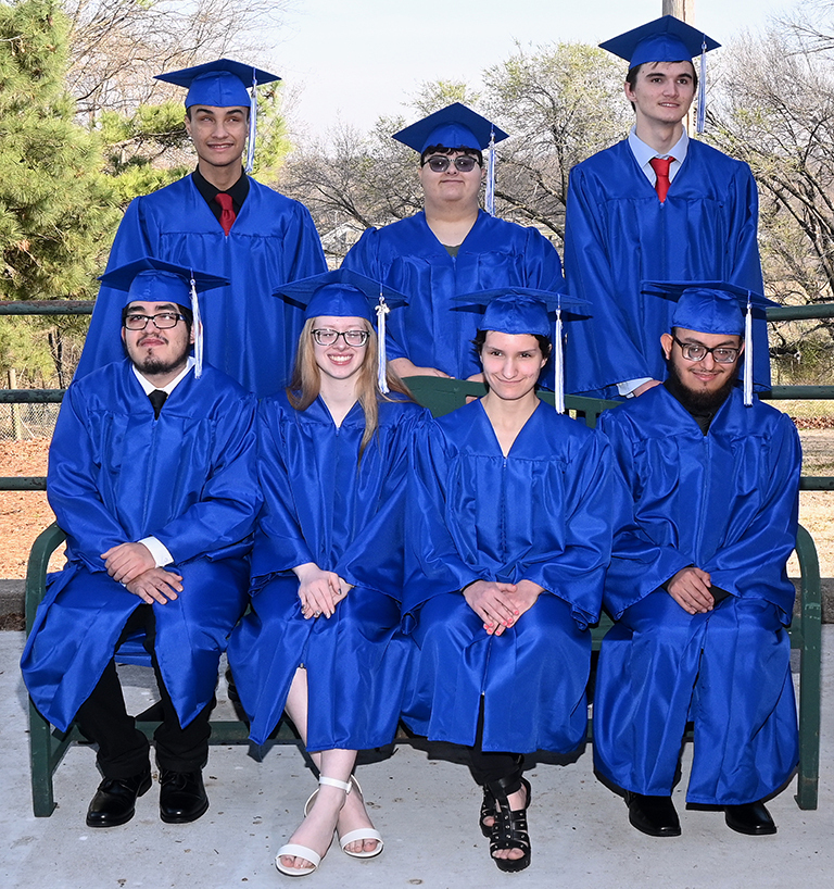 Seven OSB students wearing graduation caps and gowns.