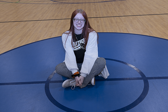 Woman sitting on basketball court.