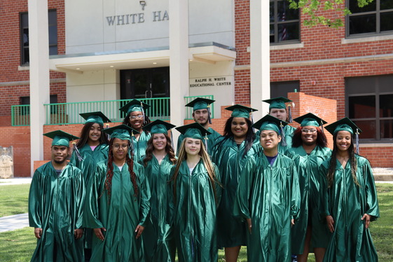 Twelve seniors wearing caps and gowns.