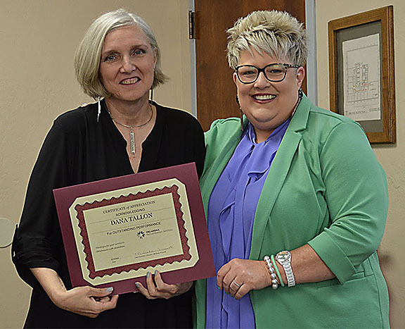 Two women with one holding a certificate.