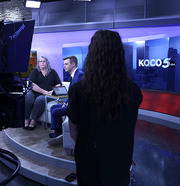 ASL interpreter looks toward woman being interviewed.
