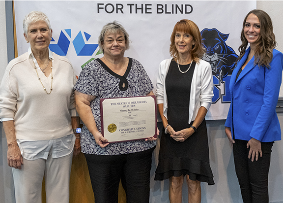 Four women with one holding a certificate. 