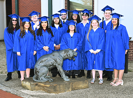 Twelve students in caps and gowns.