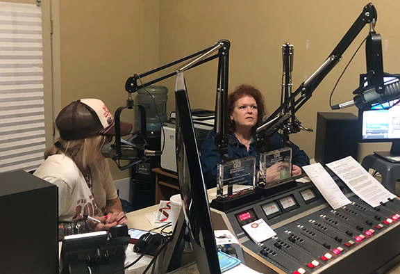 Two women sitting in front of radio microphones.