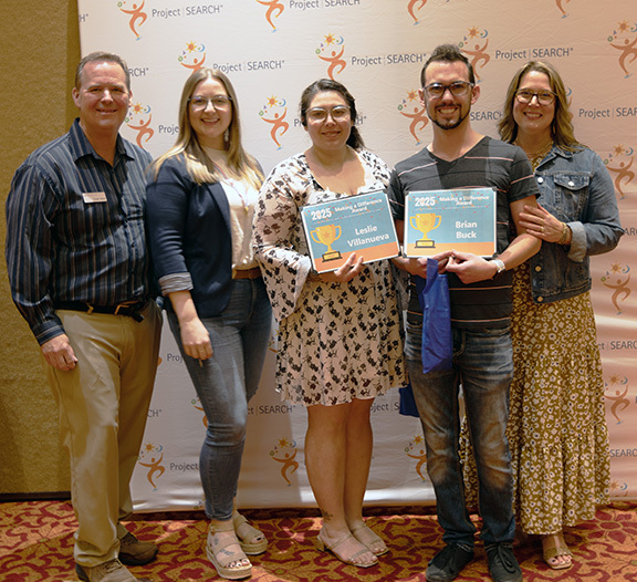 Five people with two holding awards.