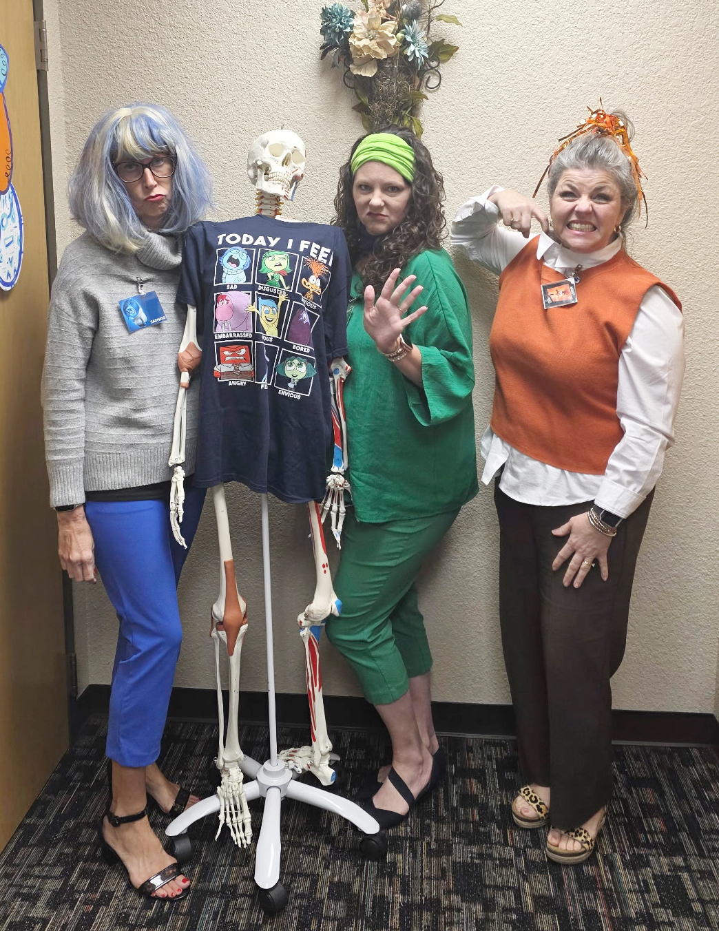 Three women psoing with a skeleton.