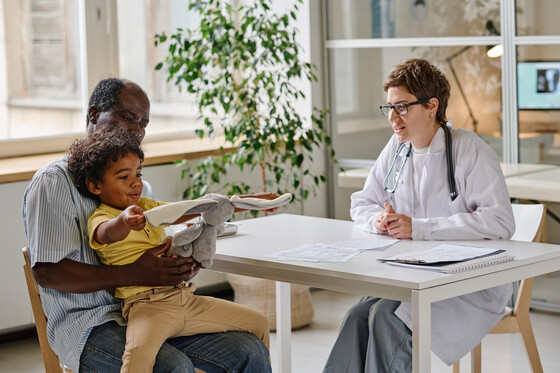 Photo of doctor talking to patient with little boy