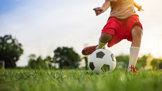 Photo of boy kicking a soccer ball