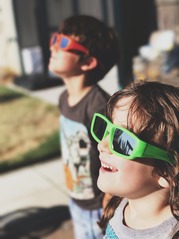 Photo of kids looking through solar eclipse glasses