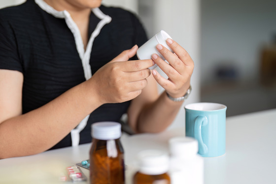 Photo of a woman looking at a medication bottle