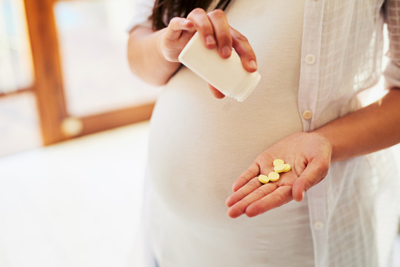 Photo of a pregnant woman taking vitamins