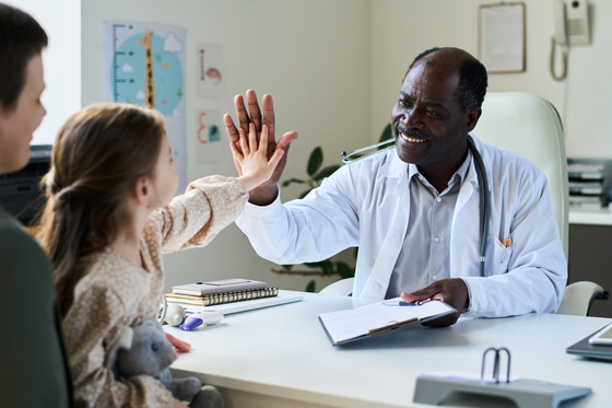 Photo of a little girl high-fiving doctor