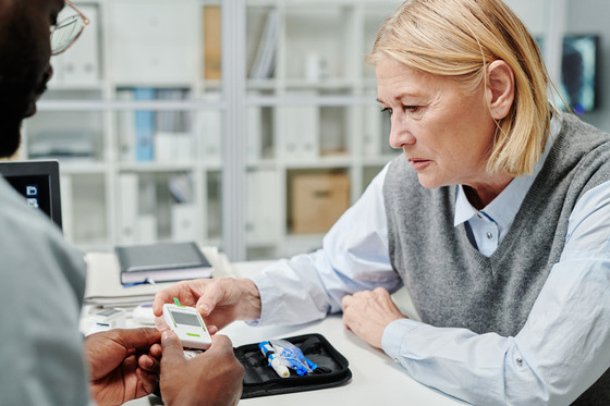 Photo of a health care worker helping woman manage diabetes