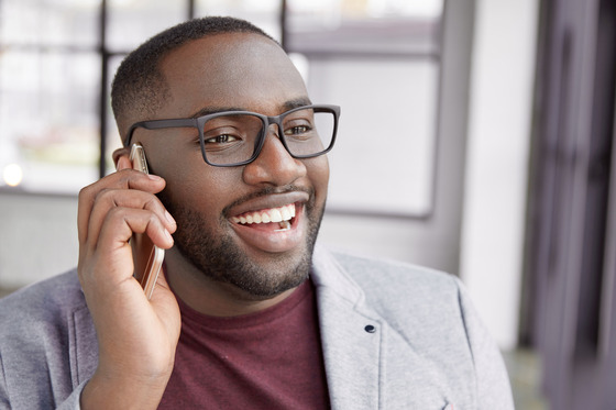 Photo of smiling man on phone