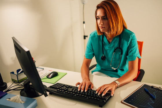 Photo of a health care worker at a computer