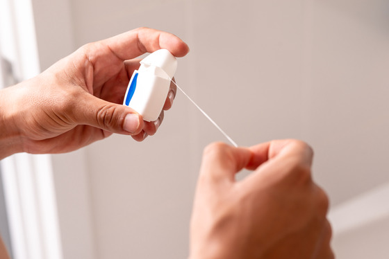 Photo of a person holding dental floss