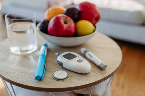 Photo of a basket of fruit and a glucose monitor on a table