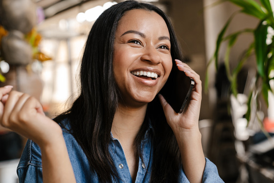 Photo of a smiling woman on the phone