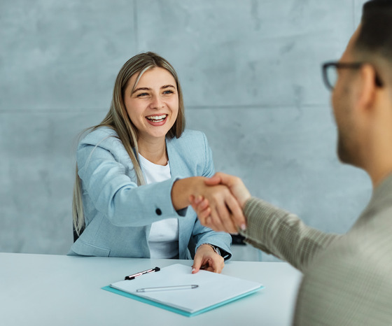 Photo of a female handshaking with a male during an interview
