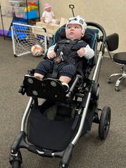 Stetson sits in his Zippie stroller. The seat is partially reclined and raised into a supportive position.