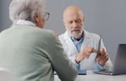 Photo of a senior female patient with a doctor who is showing her an X-ray