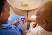 Photo of a health care worker providing support and education to a diabetic patient