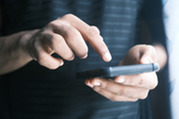 Photo of a man typing on his phone