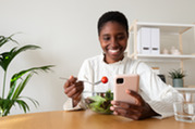 Photo of a smiling woman eating a nutritious salad