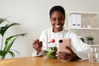 Photo of a smiling woman eating a nutritious salad