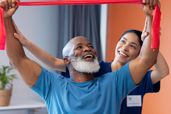 Photo of a man being assisted during a physical therapy session