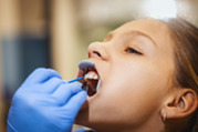 Photo of a child at the dentist with her mouth open