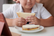 Photo of a young boy eating a sandwich